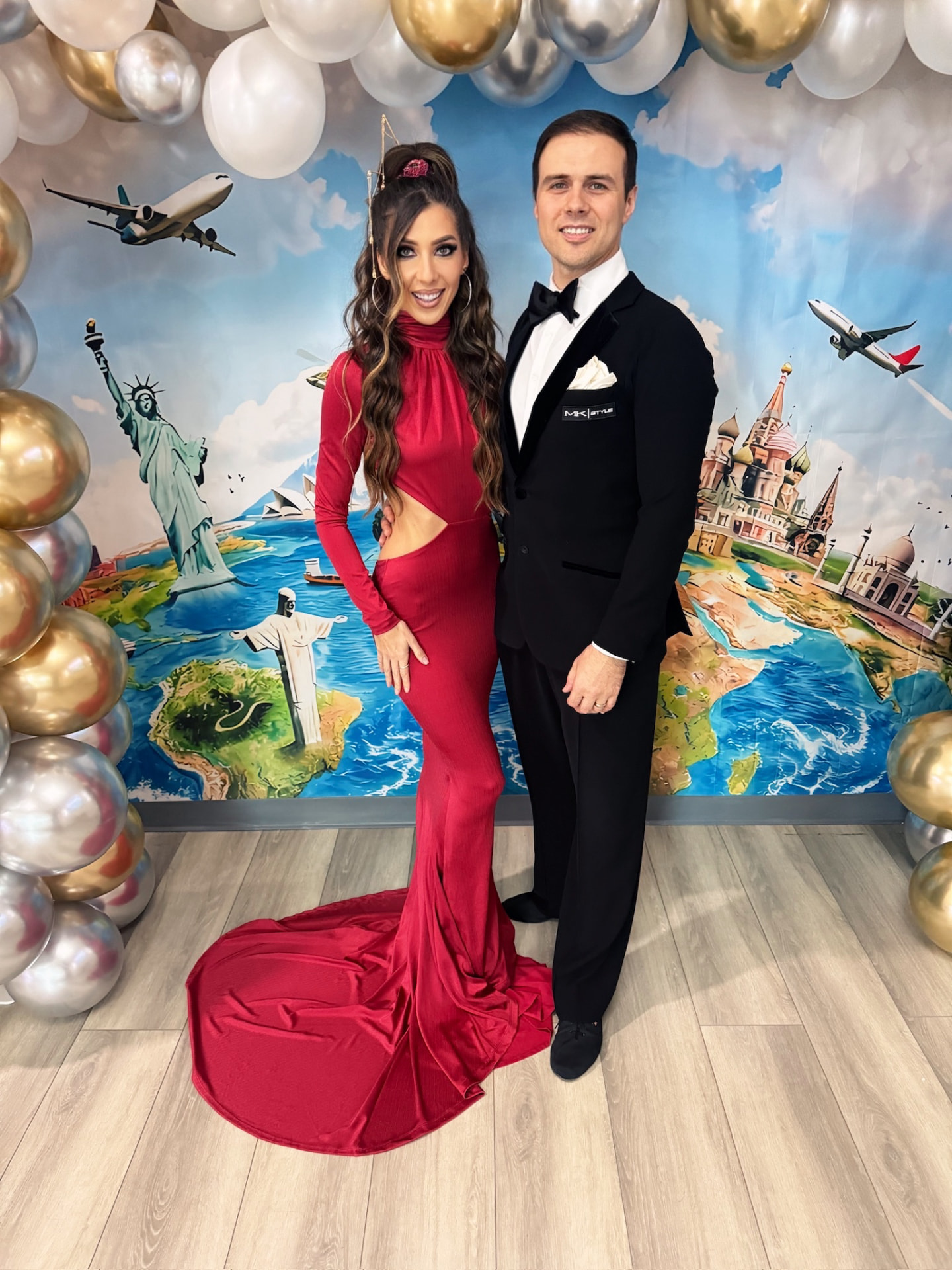 Couple in red gown and tuxedo at the Around the World Showcase backdrop
