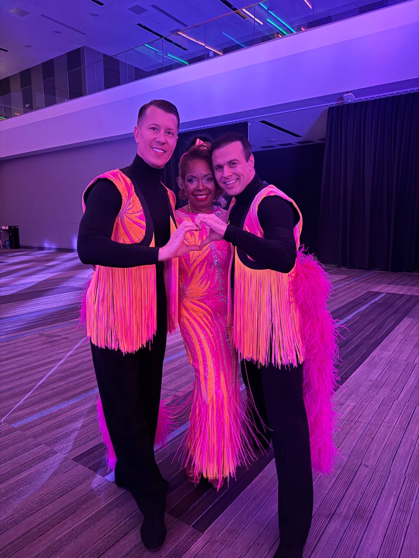 Performers in vibrant pink and orange costumes